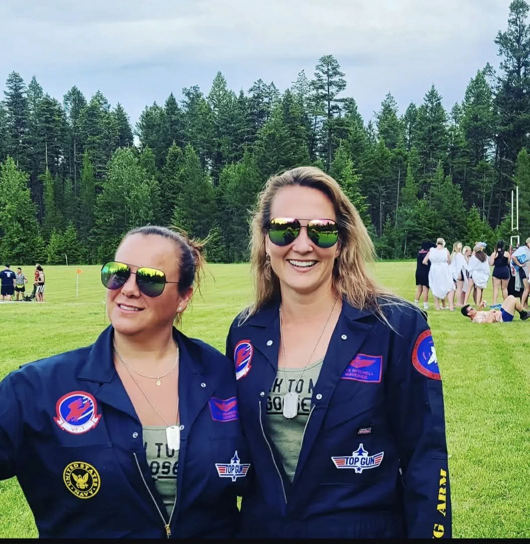 Two women wearing Top Gun themed coveralls
